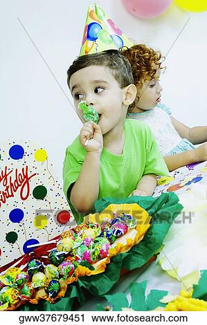 Boy eating candy at a birthday party View Large Photo Image Stock Image - Boy eating candy at a birthday party. Fotosearch