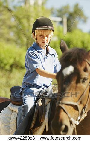 Stock Image - Boy horseback riding. Fotosearch