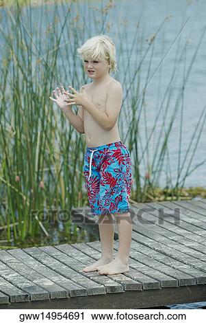 Boy standing on a pier View Large Photo Image Stock Image - Boy standing on a pier. Fotosearch
