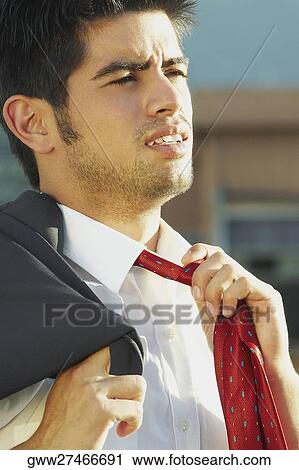 Stock Image - Businessman adjusting his tie. Fotosearch
