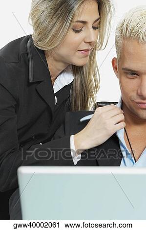 Stock Image - Businessman and a businesswoman in front of a laptop. Fotosearch