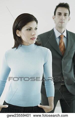 Businessman and a businesswoman standing with their hands in their pockets View Large Photo Image Stock Image - Businessman and a businesswoman standing with their hands in their pockets. Fotosearch