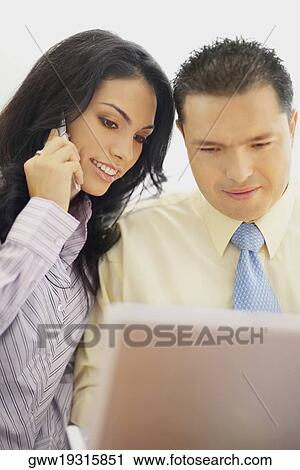 Stock Image - Businessman and a businesswoman working together. Fotosearch