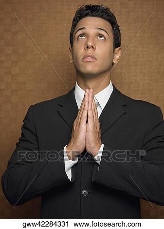 Stock Image - Businessman in a prayer position. Fotosearch