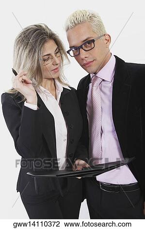Businesswoman holding a file with a businessman standing beside her View Large Photo Image Stock Image - Businesswoman holding a file with a businessman standing beside her. Fotosearch