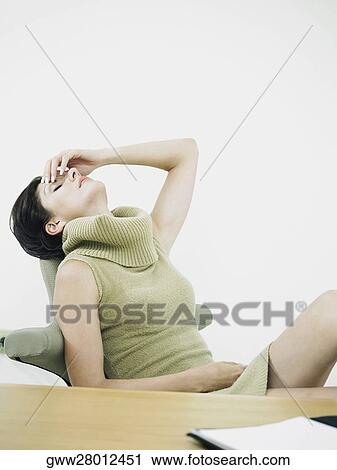 Stock Image - Businesswoman suffering from a headache. Fotosearch