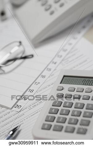 Stock Image - Calculator and telephone with eyeglasses on paper. Fotosearch