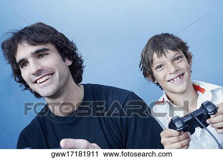 Stock Image - Close-up of a boy and his father playing a video game. Fotosearch