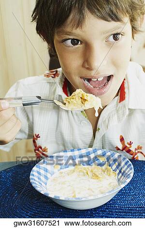 Close-up of a boy eating corn flakes View Large Photo Image Stock Image - Close-up of a boy eating corn flakes. Fotosearch