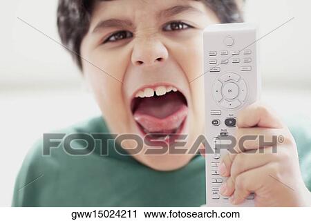 Close-up of a boy holding a remote control and shouting View Large Photo Image Stock Image - Close-up of a boy holding a remote control and shouting. Fotosearch