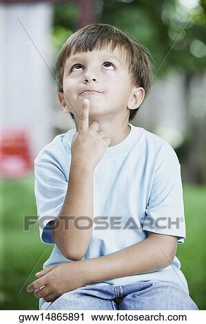Stock Image - Close-up of a boy looking up and thinking. Fotosearch