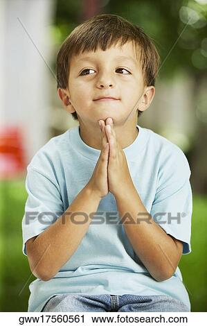 Close-up of a boy sitting in a prayer position View Large Photo Image Stock Image - Close-up of a boy sitting in a prayer position. Fotosearch