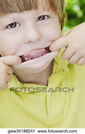Close-up of a boy stretching his mouth with his fingers View Large Photo Image Stock Image - Close-up of a boy stretching his mouth with his fingers. Fotosearch