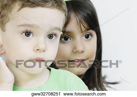 Close-up of a boy with a girl smiling behind him View Large Photo Image Stock Image - Close-up of a boy with a girl smiling behind him. Fotosearch