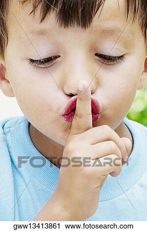 Close-up of a boy with his finger on his lips View Large Photo Image Stock Image - Close-up of a boy with his finger on his lips. Fotosearch