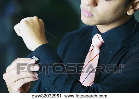 Close-up of a businessman buttoning his cuff View Large Photo Image Stock Image - Close-up of a businessman buttoning his cuff. Fotosearch