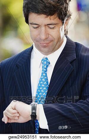 Close-up of a businessman checking the time View Large Photo Image Stock Image - Close-up of a businessman checking the time. Fotosearch