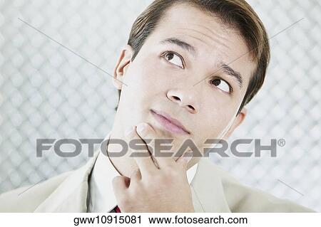 Close-up of a businessman thinking with his hand on his chin View Large Photo Image Stock Image - Close-up of a businessman thinking with his hand on his chin. Fotosearch