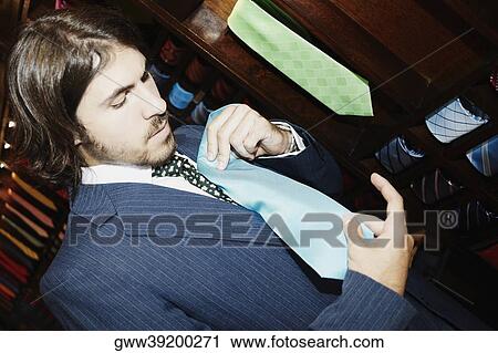 Close-up of a businessman trying on a tie in a clothing store View Large Photo Image Stock Image - Close-up of a businessman trying on a tie in a clothing store. Fotosearch
