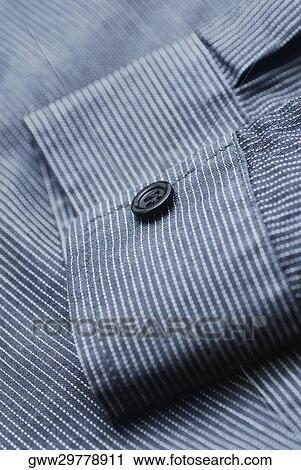 Stock Image - Close-up of a button on the sleeve of a shirt. Fotosearch