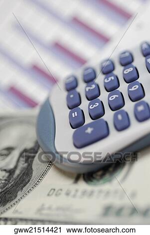 Stock Image - Close-up of a calculator and one hundred dollar bill. Fotosearch