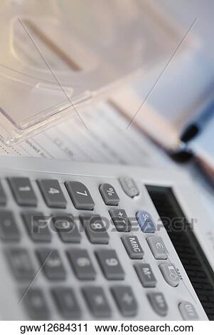 Close-up of a calculator with a pen on documents View Large Photo Image Stock Image - Close-up of a calculator with a pen on documents. Fotosearch