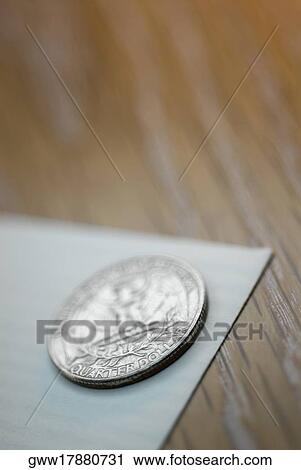 Stock Image - Close-up of a coin on a sheet of paper. Fotosearch