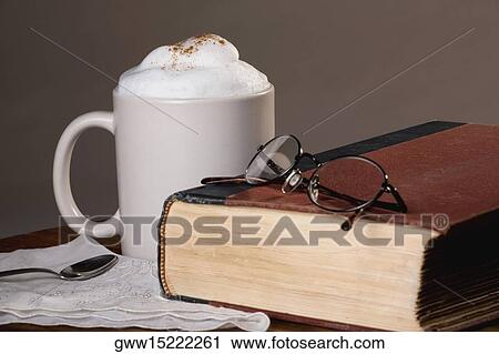 Close-up of a cup of coffee with a book View Large Photo Image Stock Image - Close-up of a cup of coffee with a book. Fotosearch