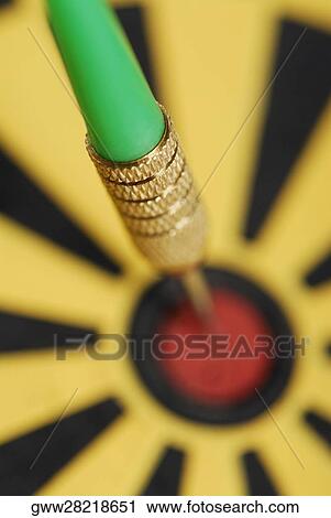 Stock Image - Close-up of a dart on a dartboard. Fotosearch