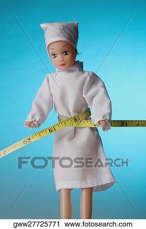 Stock Image - Close-up of a doll with a tape measure. Fotosearch