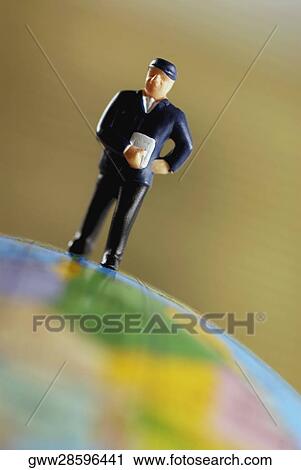 Stock Image - Close-up of a figurine on a globe. Fotosearch