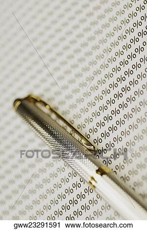 Stock Image - Close-up of a fountain pen on a sheet of percentage signs. Fotosearch