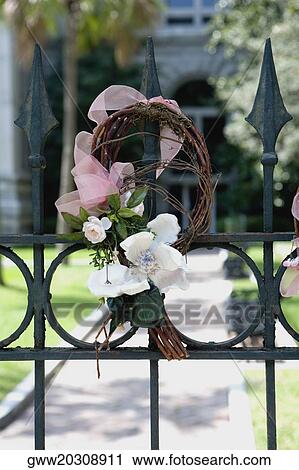 Stock Image - Close-up of a gate decorated with flowers. Fotosearch