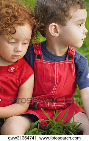 Close-up of a girl and her brother sitting together View Large Photo Image Stock Image - Close-up of a girl and her brother sitting together. Fotosearch