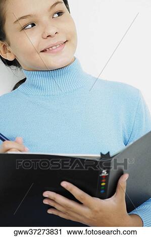 Close-up of a girl holding a pen and a spiral notebook View Large Photo Image Stock Image - Close-up of a girl holding a pen and a spiral notebook. Fotosearch
