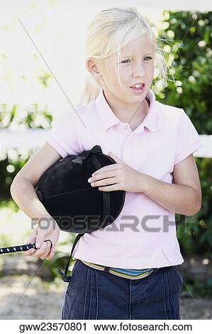 Close-up of a girl holding a riding hat View Large Photo Image Stock Image - Close-up of a girl holding a riding hat. Fotosearch