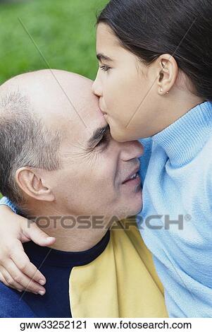 Close-up of a girl kissing her father on his forehead View Large Photo Image Stock Image - Close-up of a girl kissing her father on his forehead. Fotosearch