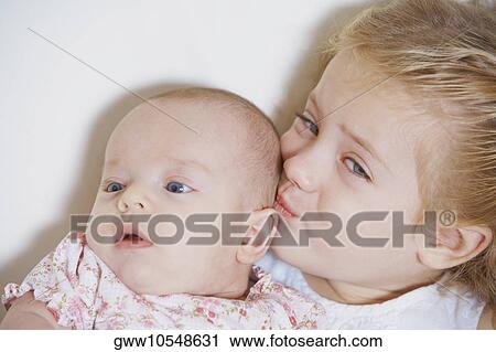 Close-up of a girl kissing her sister View Large Photo Image Stock Image - Close-up of a girl kissing her sister. Fotosearch