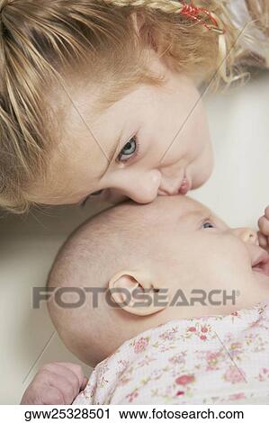 Close-up of a girl kissing her sister View Large Photo Image Stock Image - Close-up of a girl kissing her sister. Fotosearch