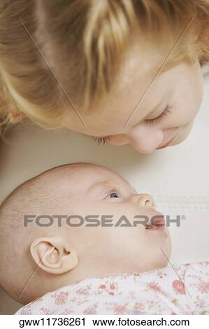 Stock Image - Close-up of a girl looking down at her sister. Fotosearch