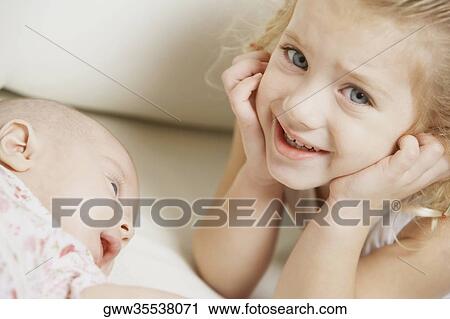 Stock Image - Close-up of a girl smiling with her sister. Fotosearch
