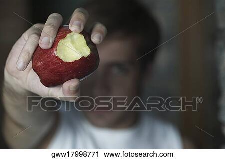 Close-up of a human hand holding a partially eaten apple View Large Photo Image Stock Image - Close-up of a human hand holding a partially eaten apple. Fotosearch