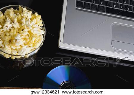 Stock Image - Close-up of a laptop with a bowl of popcorn and a CD. Fotosearch