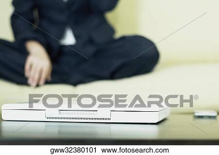 Close-up of a laptop with a business executive sitting beside it View Large Photo Image Stock Image - Close-up of a laptop with a business executive sitting beside it. Fotosearch