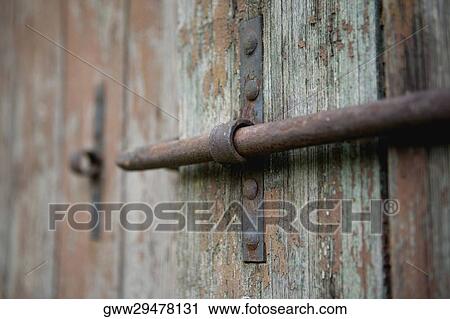 Stock Image - Close-up of a latch on a wooden door. Fotosearch