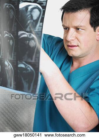 Close-up of a male doctor examining an X-Ray View Large Photo Image Stock Image - Close-up of a male doctor examining an X-Ray. Fotosearch