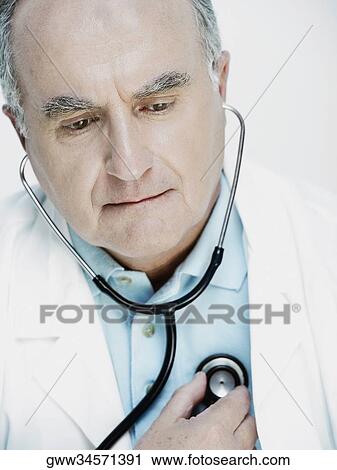 Close-up of a male doctor examining himself with a stethoscope View Large Photo Image Stock Image - Close-up of a male doctor examining himself with a stethoscope. Fotosearch