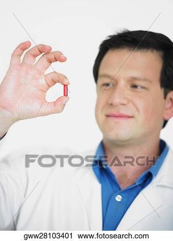 Close-up of a male doctor holding a capsule View Large Photo Image Stock Image - Close-up of a male doctor holding a capsule. Fotosearch