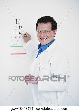 Stock Image - Close-up of a male doctor pointing towards an eye chart. Fotosearch