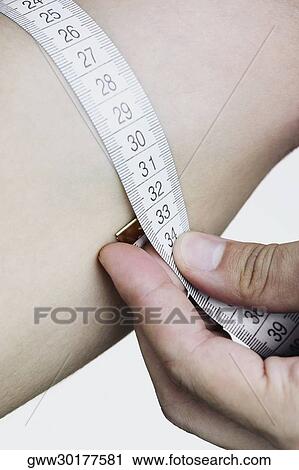 Close-up of a man measuring his arms View Large Photo Image Stock Image - Close-up of a man measuring his arms. Fotosearch
